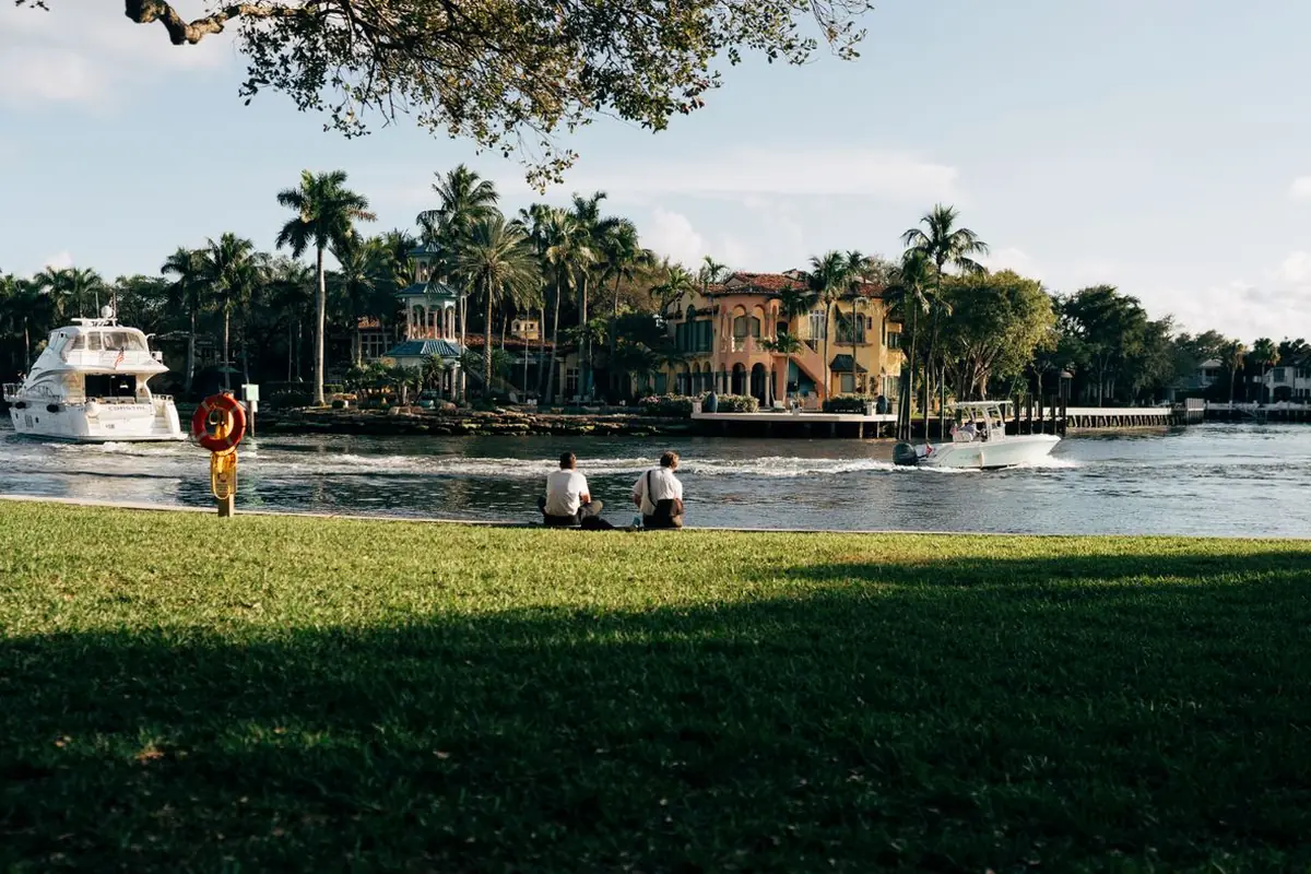 Palm trees, a grassy riverbank and boats on the water in Southwest Florida